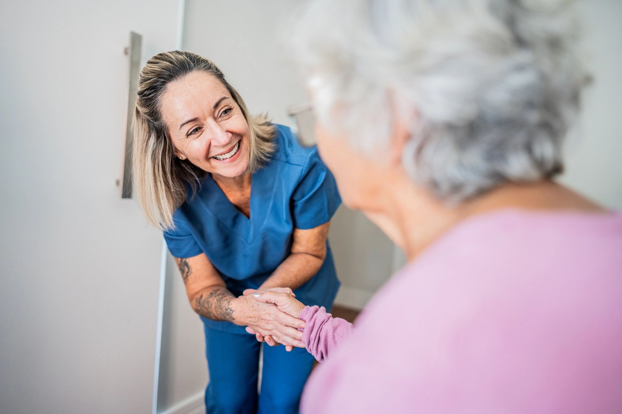 Compassionate nurse supporting a senior woman