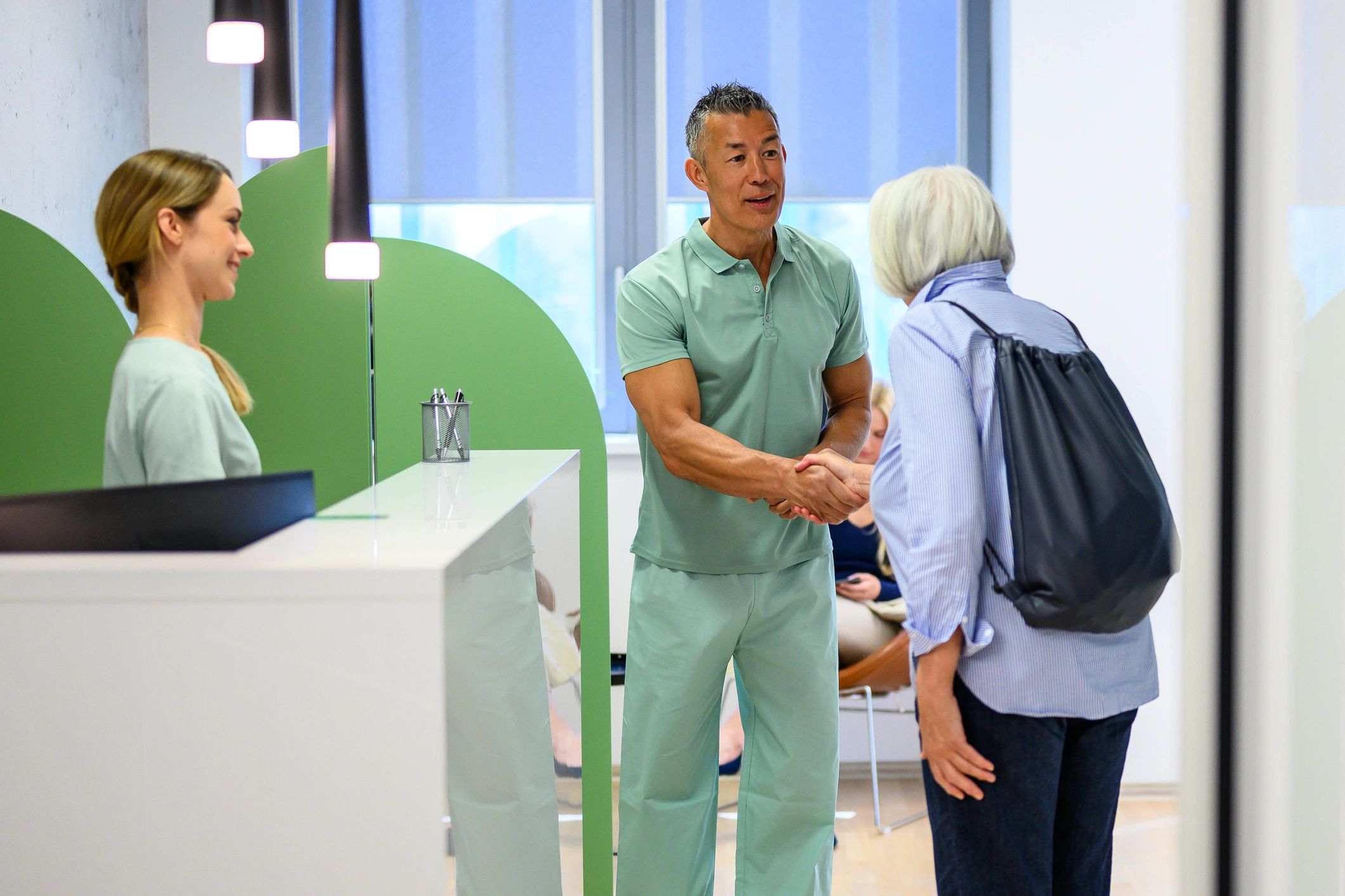 Physical therapist greeting an elderly patient in a welcoming rehabilitation clinic