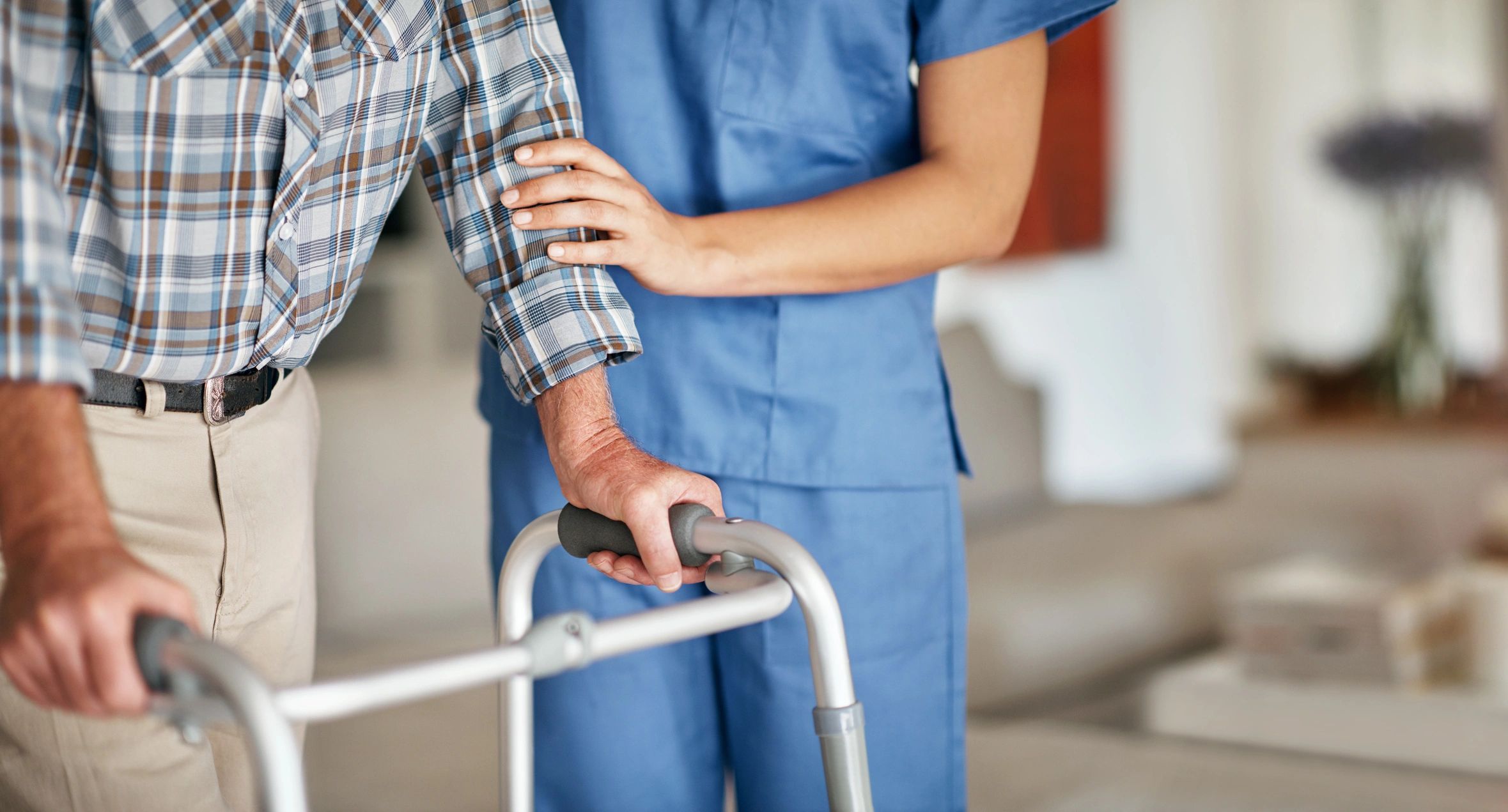 Caregiver assisting an elderly patient using a walker